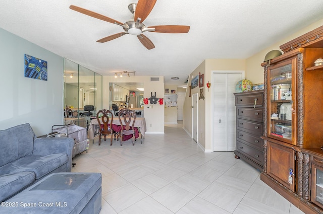 living room with a ceiling fan and baseboards