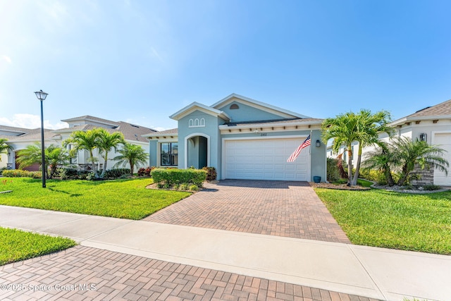 2162 Great Belt Cir, Melbourne, FL 32940 - mediterranean / spanish house featuring decorative driveway, an attached garage, a front lawn, and stucco siding