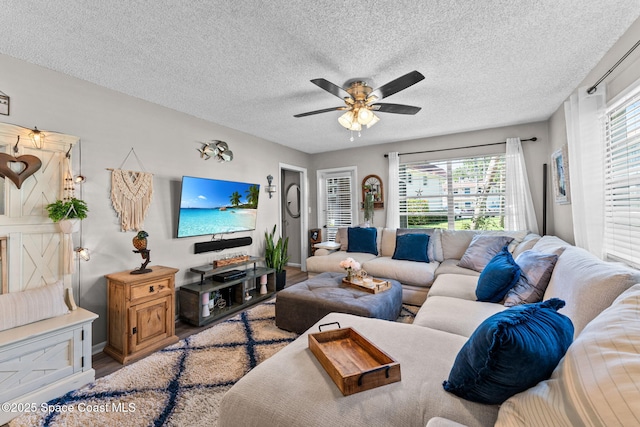 261 Cape Shores Cir Unit 18-E, Cape Canaveral, FL 32920 - living area with wood finished floors, ceiling fan, a textured ceiling, and baseboards