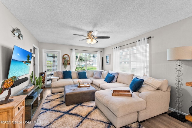 261 Cape Shores Cir Unit 18-E, Cape Canaveral, FL 32920 - living area featuring wood finished floors, ceiling fan, and a textured ceiling