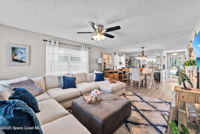 261 Cape Shores Cir Unit 18-E, Cape Canaveral, FL 32920 - living area with wood finished floors, plenty of natural light, ceiling fan, a chandelier, and a textured ceiling