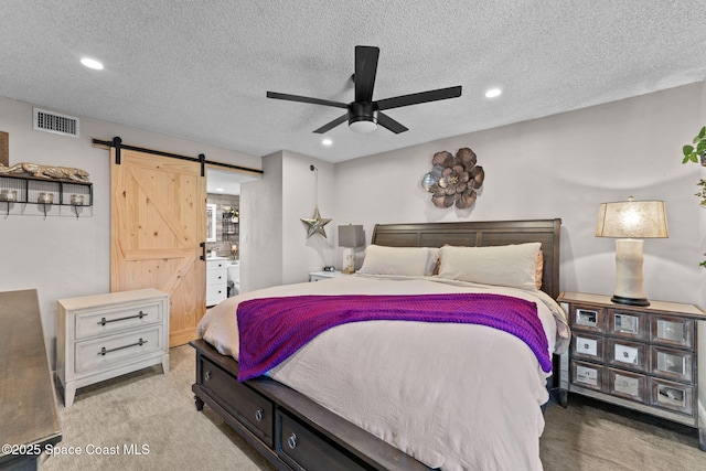 261 Cape Shores Cir Unit 18-E, Cape Canaveral, FL 32920 - carpeted bedroom featuring a barn door, recessed lighting, a textured ceiling, and ceiling fan