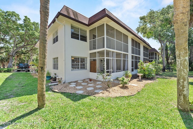 261 Cape Shores Cir Unit 18-E, Cape Canaveral, FL 32920 - back of property with a sunroom, a lawn, and stucco siding