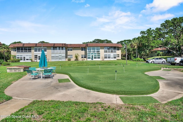 261 Cape Shores Cir Unit 18-E, Cape Canaveral, FL 32920 - view of home's community with a putting green, a yard, golf course view, and a patio area
