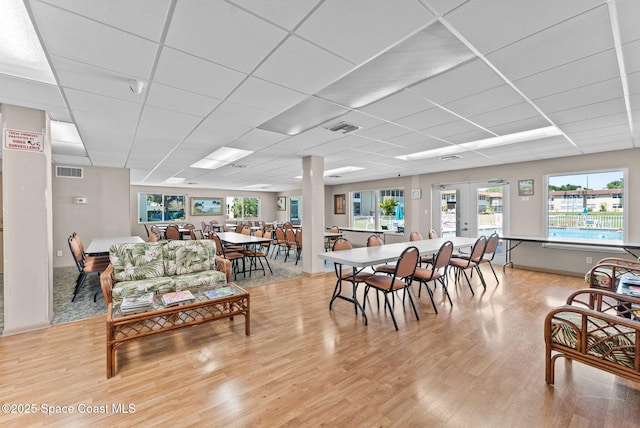 261 Cape Shores Cir Unit 18-E, Cape Canaveral, FL 32920 - dining space featuring light wood-type flooring, a drop ceiling, and baseboards