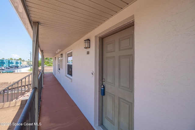 7201 Ridgewood Ave Unit 23, Cape Canaveral, FL 32920 - view of exterior entry with stucco siding and a porch