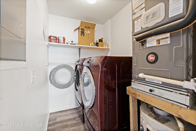 7201 Ridgewood Ave Unit 23, Cape Canaveral, FL 32920 - laundry area featuring wood finished floors, washing machine and dryer, a textured ceiling, and electric panel