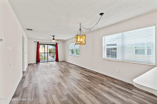 7201 Ridgewood Ave Unit 23, Cape Canaveral, FL 32920 - spare room featuring a textured ceiling, wood finished floors, a chandelier, baseboards, and ceiling fan