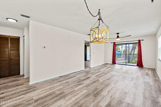 7201 Ridgewood Ave Unit 23, Cape Canaveral, FL 32920 - unfurnished room featuring a textured ceiling, a chandelier, light wood-type flooring, and ceiling fan
