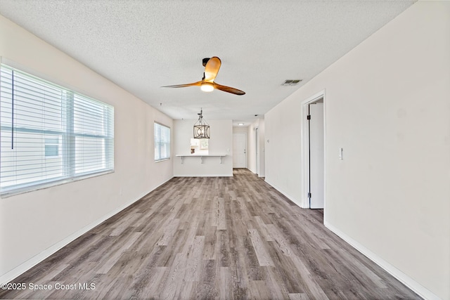 7201 Ridgewood Ave Unit 23, Cape Canaveral, FL 32920 - unfurnished living room featuring wood finished floors, a ceiling fan, a textured ceiling, and baseboards