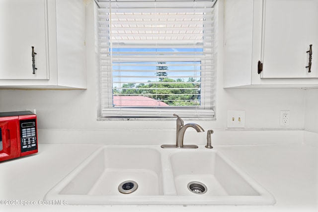 7201 Ridgewood Ave Unit 23, Cape Canaveral, FL 32920 - kitchen view of a sink, white cabinetry, and light countertops