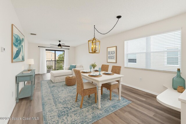 7201 Ridgewood Ave Unit 23, Cape Canaveral, FL 32920 - dining room with wood finished floors, baseboards, a chandelier, and a ceiling fan