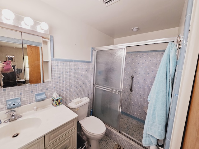 7181 Blue Shore Rd, Grant, FL 32949 - bathroom with toilet, a shower stall, vanity, tile walls, and wainscoting