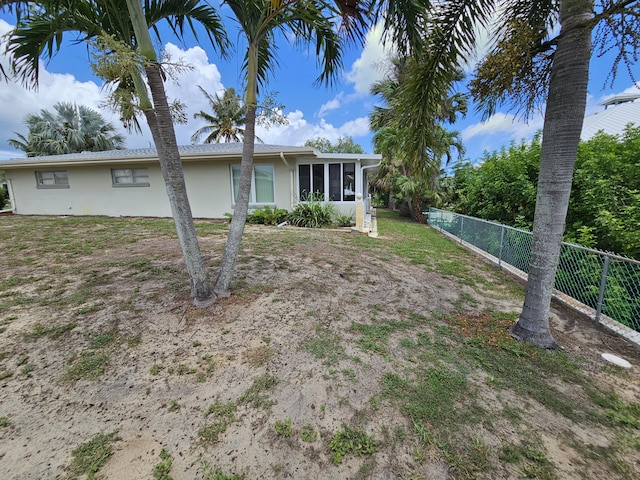 7181 Blue Shore Rd, Grant, FL 32949 - view of front of home with stucco siding, a sunroom, and fence