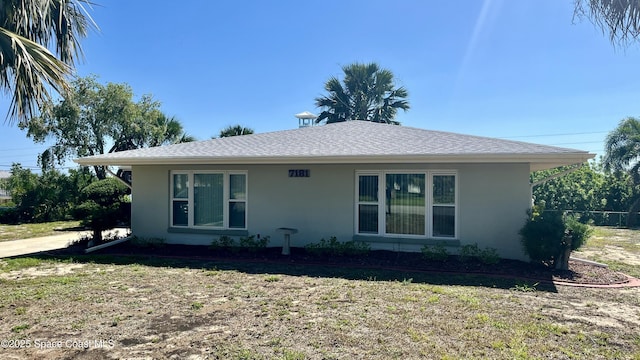 7181 Blue Shore Rd, Grant, FL 32949 - view of front facade with stucco siding and a front lawn