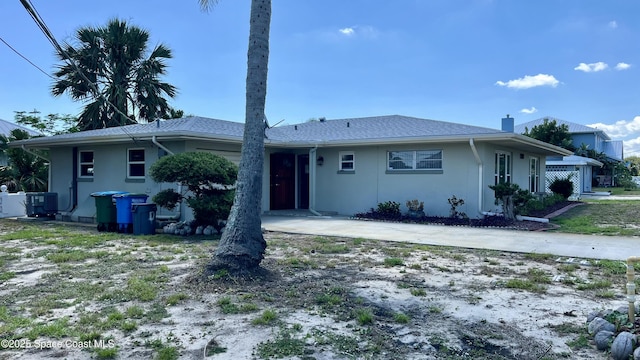 7181 Blue Shore Rd, Grant, FL 32949 - view of front facade with stucco siding, central air condition unit, and a chimney