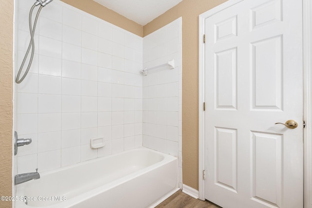 full bath with shower / washtub combination and wood finished floors