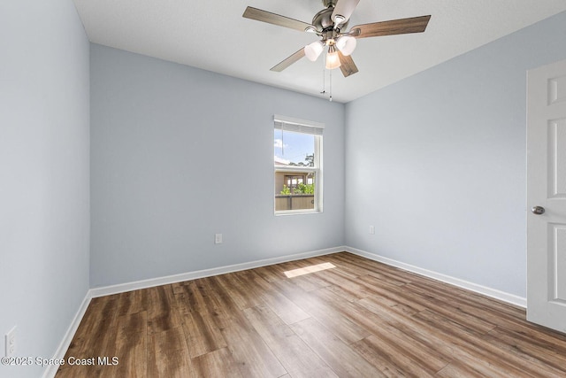 unfurnished room with wood finished floors, baseboards, and ceiling fan