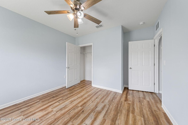 unfurnished bedroom with light wood finished floors, a closet, baseboards, and ceiling fan