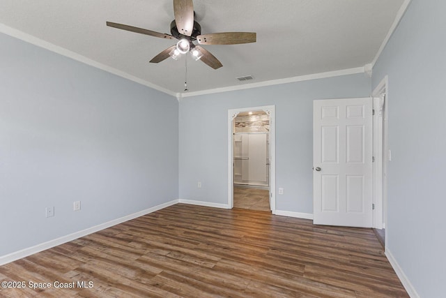 unfurnished bedroom with wood finished floors, baseboards, crown molding, ensuite bath, and a ceiling fan
