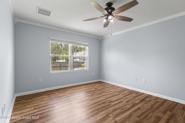 unfurnished room with crown molding, wood finished floors, a ceiling fan, and baseboards