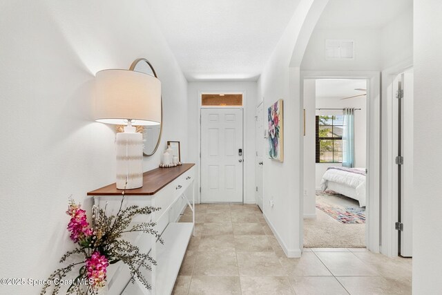369 Coyote Dr, Cocoa, FL 32927 - foyer entrance featuring light tile patterned floors, arched walkways, and baseboards