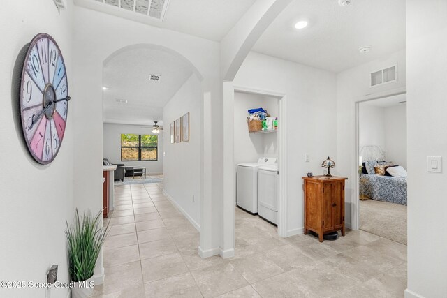 369 Coyote Dr, Cocoa, FL 32927 - hallway with arched walkways, washing machine and dryer, light tile patterned flooring, and baseboards