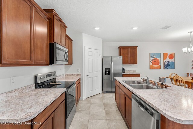 369 Coyote Dr, Cocoa, FL 32927 - kitchen featuring stainless steel appliances, a sink, a chandelier, light countertops, and a center island with sink