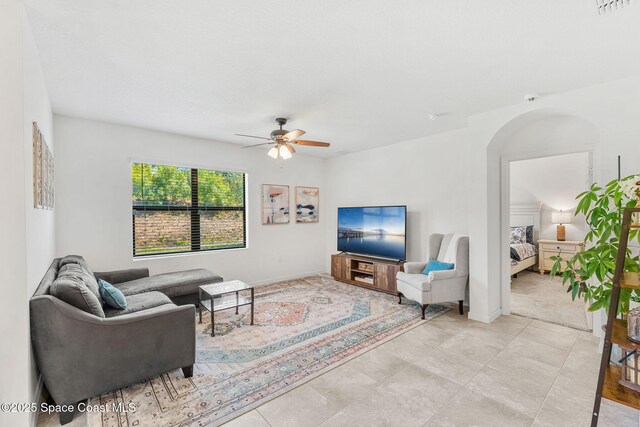 369 Coyote Dr, Cocoa, FL 32927 - living room featuring a ceiling fan, arched walkways, and baseboards