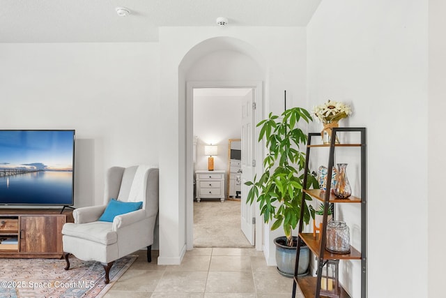 369 Coyote Dr, Cocoa, FL 32927 - sitting room featuring arched walkways, light tile patterned floors, and light colored carpet