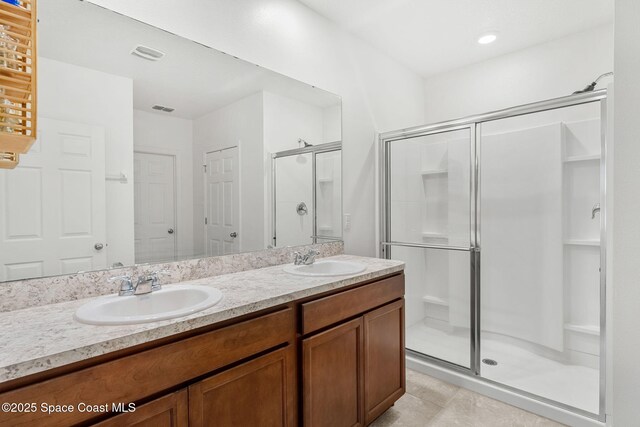 369 Coyote Dr, Cocoa, FL 32927 - full bathroom with a stall shower, double vanity, and tile patterned flooring