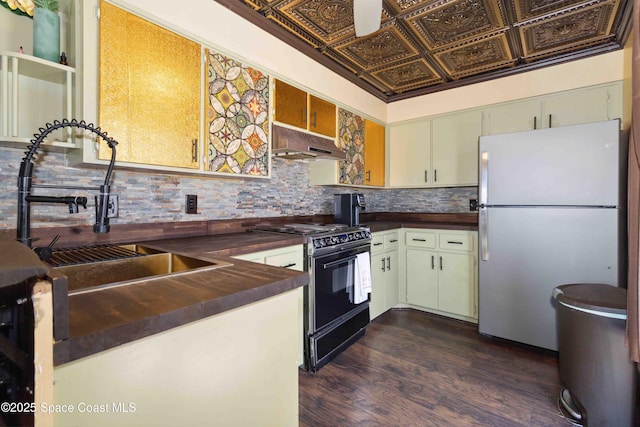 326 Pierce Ave, Cape Canaveral, FL 32920 - kitchen with freestanding refrigerator, under cabinet range hood, black range with electric stovetop, dark countertops, and a sink