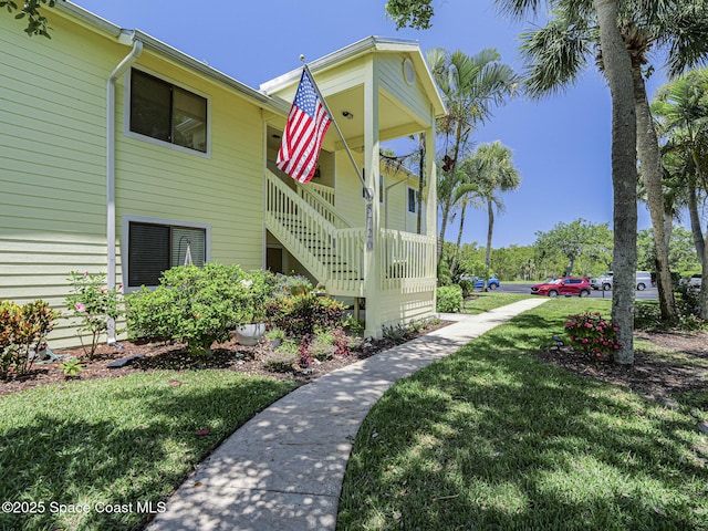 5720 Marina Dr Unit 2, Sebastian, FL 32958 - view of home's exterior with a lawn, covered porch, and stairway