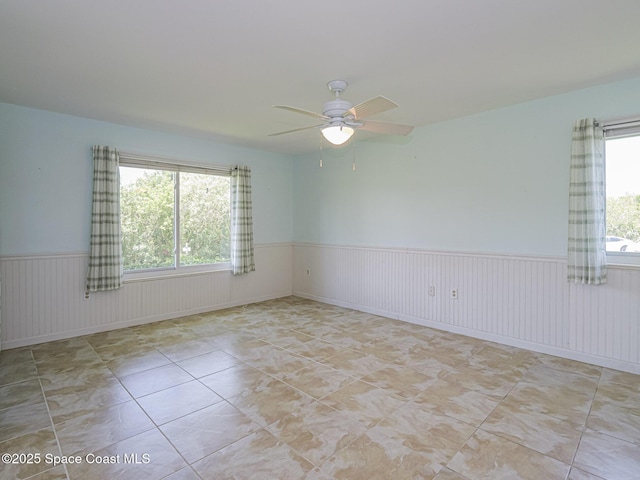 5720 Marina Dr Unit 2, Sebastian, FL 32958 - tiled empty room featuring wainscoting and a ceiling fan