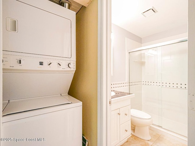 5720 Marina Dr Unit 2, Sebastian, FL 32958 - washroom with stacked washing machine and dryer and light tile patterned floors