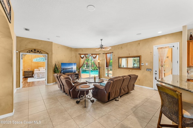 living room featuring light tile patterned flooring, a ceiling fan, baseboards, and recessed lighting