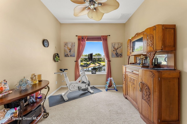 workout room with light colored carpet, ceiling fan, and baseboards