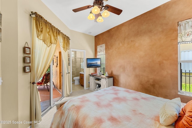 bedroom featuring light colored carpet, ensuite bath, access to outside, and ceiling fan