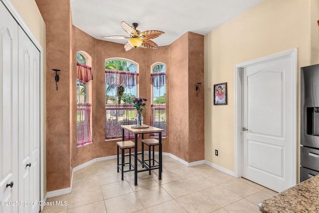 dining room with light tile patterned floors, ceiling fan, and baseboards