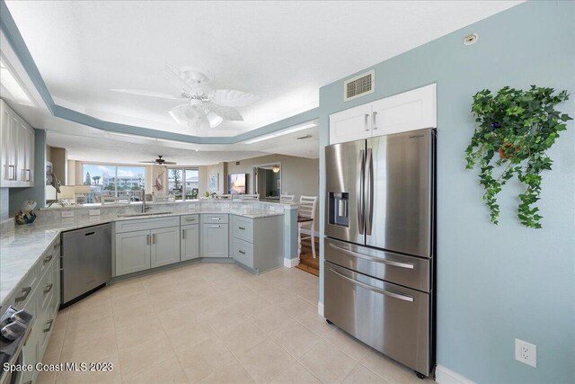 3360 S Atlantic Ave Unit 301, Cocoa Beach, FL 32931 - kitchen with stainless steel appliances, a sink, a peninsula, ceiling fan, and light stone counters