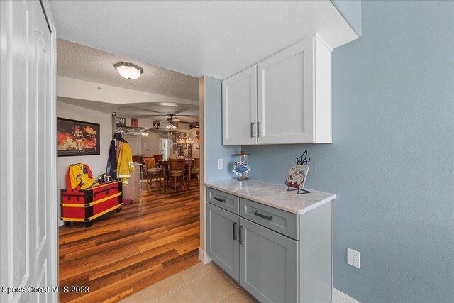 3360 S Atlantic Ave Unit 301, Cocoa Beach, FL 32931 - bar featuring a ceiling fan, arched walkways, light tile patterned floors, a textured ceiling, and baseboards
