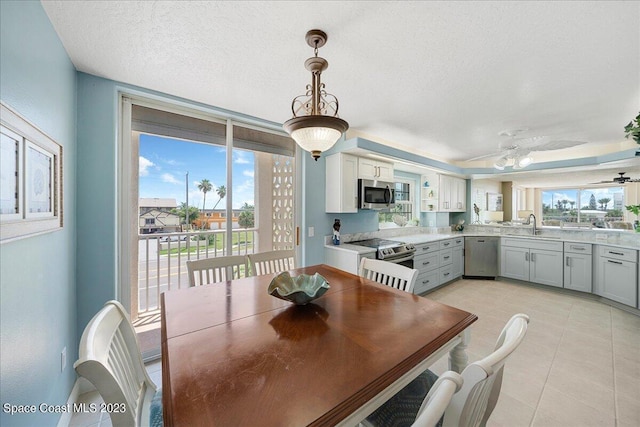 3360 S Atlantic Ave Unit 301, Cocoa Beach, FL 32931 - dining area featuring healthy amount of natural light, a textured ceiling, light tile patterned floors, and ceiling fan