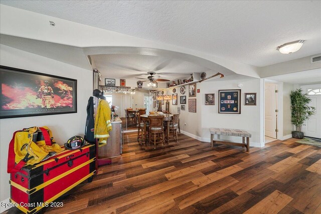 3360 S Atlantic Ave Unit 301, Cocoa Beach, FL 32931 - dining room featuring a ceiling fan, wood finished floors, a textured ceiling, baseboards, and arched walkways