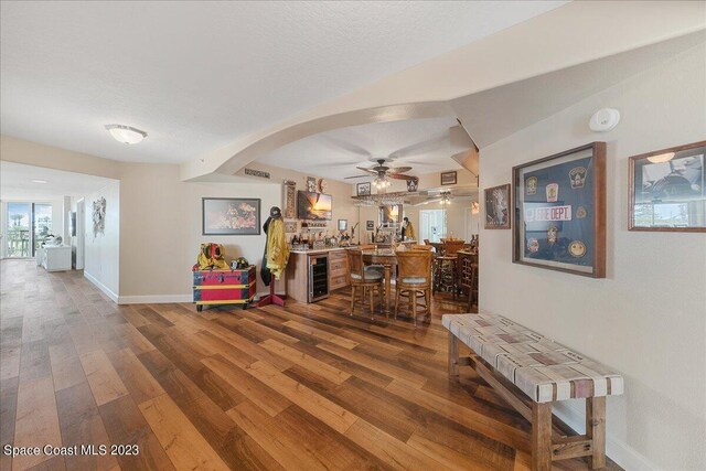 3360 S Atlantic Ave Unit 301, Cocoa Beach, FL 32931 - dining room with wine cooler, wood finished floors, a ceiling fan, baseboards, and arched walkways