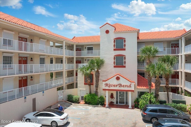 3360 S Atlantic Ave Unit 301, Cocoa Beach, FL 32931 - view of apartment building / complex featuring uncovered parking