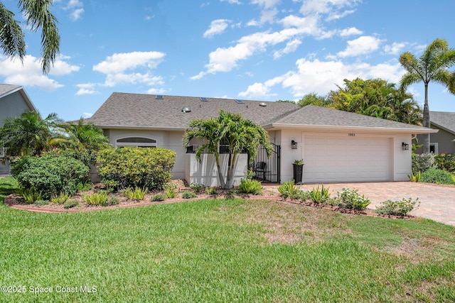 1863 Freedom Dr, Melbourne, FL 32940 - ranch-style house with a garage, decorative driveway, a front yard, and stucco siding