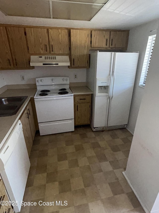 1602 University Ln Unit 1307, Cocoa, FL 32922 - kitchen featuring white appliances, range hood, light floors, a sink, and light countertops
