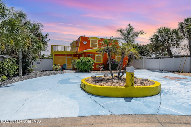 303 Winslow Cir, Cocoa Beach, FL 32931 - view of front of house featuring curved driveway and a balcony