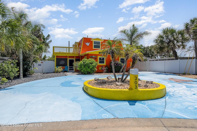303 Winslow Cir, Cocoa Beach, FL 32931 - view of front facade with a balcony and curved driveway