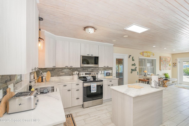 303 Winslow Cir, Cocoa Beach, FL 32931 - kitchen featuring appliances with stainless steel finishes, a sink, backsplash, wooden ceiling, and a center island